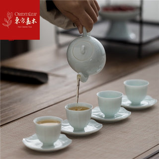 The handmade celadon teapot from China is pouring tea.