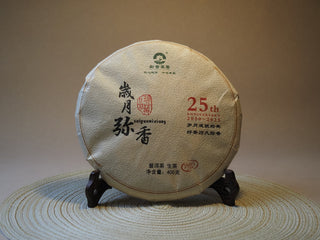 Front view of "The Patient Years" 2005 Lincang vintage raw Sheng Pu-erh tea cake in traditional paper wrapper.