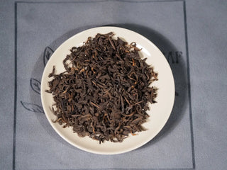 Close-up of Grade 1 2013 Aged Liubao Dark Tea dry leaves, showing tight ropes and golden tips that indicate premium Wuzhou factory craftsmanship.