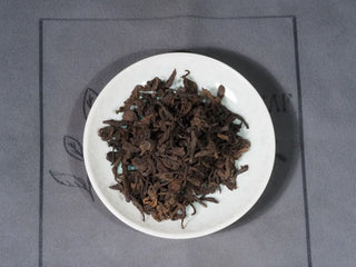 2014 Aged Liubao Dark Tea dry leaves close-up, showcasing tight, glossy texture, known for Betel Nut Aroma and Cooling Finish.