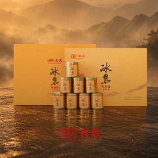 Mengku Rongshi 2026 Bingdao Aged Ripe Pu-erh coin cake gift set: 7 golden tins and box on a dark surface with mountain backdrop.