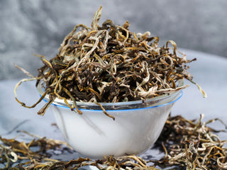 Dry leaves of Ailao Golden Tips Grade 1 Yunnan Yellow Tea showing fuzzy silver and gold buds.