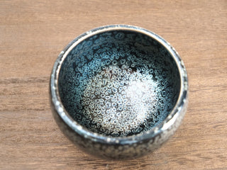 Top view of Bu Dao Weng sky eye oil spot Jianzhan tea bowl, showing dense silver-blue crystals across the entire interior on a deep black ground.