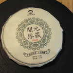 Front view of Kaiyuan Reserve 2006 aged raw Pu-erh tea cake wrapped in traditional paper.