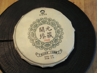 Front view of Kaiyuan Reserve 2006 aged raw Pu-erh tea cake wrapped in traditional paper.