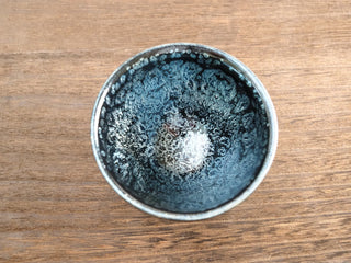 Top view of Shu Kou sky eye oil spot Jianzhan tea bowl, showing dense silver crystals on a deep black glaze across the entire interior.