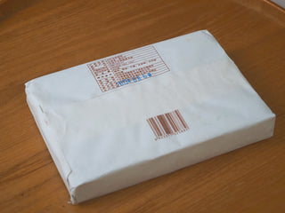 Back view of the 2013 Lincang Ripe Pu-erh Ancient Tree Tea Brick in its sealed paper wrapper with barcode and label details.