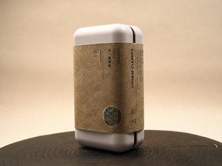 White tin box for 2014 Fuding Shou Mei waffle cake with kraft paper band, silver seal and FASHION GIFTS label on the front.