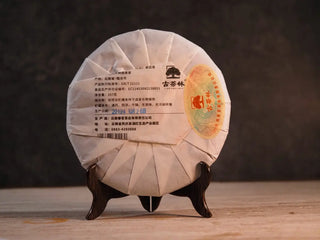 Back packaged view of 2019 Qilin Tribute Sheng Pu-erh Tea Cake – Ancient Arbor 357g, highlighting the paper wrapper details and factory stamp.