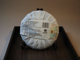 Back view showing the product certification label and details on the 2019 Tan Chun raw puerh tea wrapper.