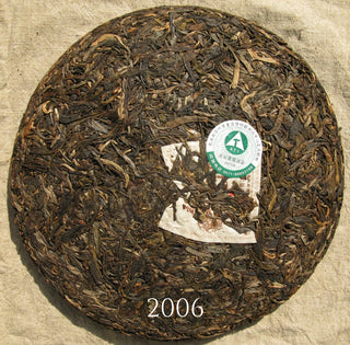 Close-up of the aged leaves on the surface of a 2006 vintage raw Puerh tea cake.