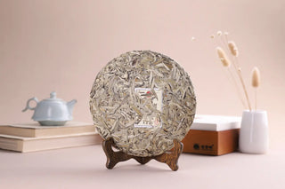 Close-up of 2018 Fengqing Silver Needle White Tea cake showing abundant silver buds and tea down.