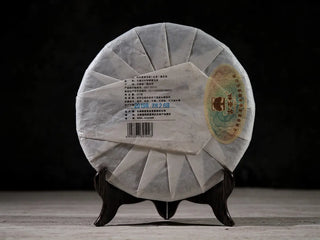 Back view of 2019 Lincang Ancient Arbor Sheng Pu-erh Tea Cake 357g showing paper wrapper details and authenticity seal