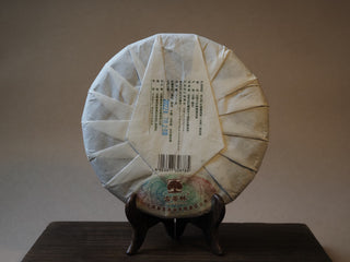 Back view of wrapped 2022 Mangfei Mountain sheng Pu-erh tea cake