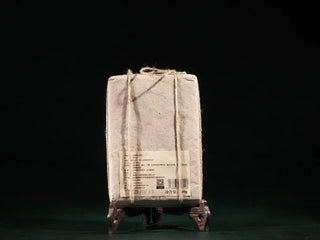 Traditional paper-wrapped On Taoism Fuzhuan Tea Brick, allowing the Golden Flower fungi to breathe and convert.