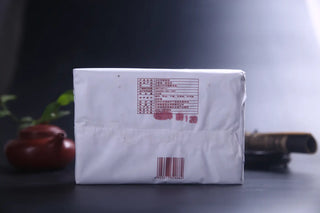 Back view of 2006 vintage shou pǔ'ěr tea brick packaging with product details and manufacturer information.