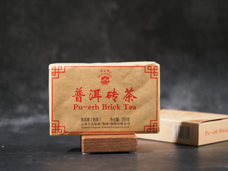 Side profile and packaging of Xiaguan Baoyan fermented Puerh tea brick.