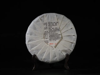 Back view of Yunnan Jinggu White Peony Tea Cake 357g in original packaging, highlighting stone-pressed details and traditional labeling