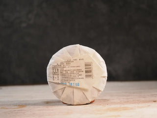 Snow Mountain Rare Wild Ancient Tree Sheng Pu-erh (2016–2023) – 100g Mini Cake, back view with packaging, highlighting product details and label