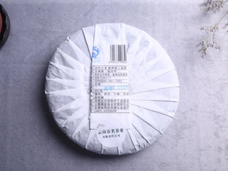 Close-up of the Yunnan Sheng Puerh Blend in its complete, traditional white paper wrapper.