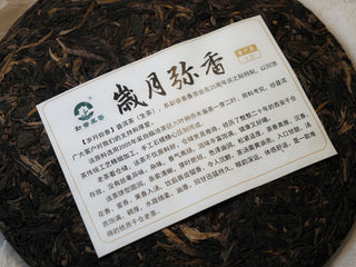 Detailed close-up of the historical wrapper information and branding text for the 2005 Lincang aged raw Pu-erh tea.