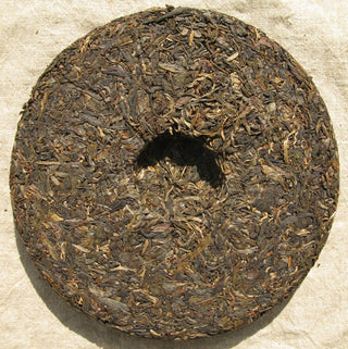 Back side of 2005 Mengku raw Pu-erh tea cake showing the traditional compression dimple.
