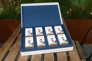 Opened presentation box of Mengku Rongshi 2020 Bingdao Aged Raw Pu-erh coin cakes: 8 small white boxes in 2x4 arrangement.