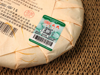 Close-up of the green anti-counterfeit label on the 2020 Bojun 500g cake, with QR code and verification barcode.