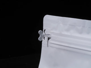Close-up of the professional-grade airtight zipper detail on a white moisture-proof tea sample bag.