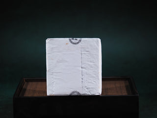 The 2013 aged Hei Cha brick wrapped in its protective white inner paper, maintaining the vitality of the Golden Flora.
