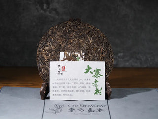 2018 Dazhai Ancient Tree Raw Pu-erh Tea Cake with packaging removed, showing product card front