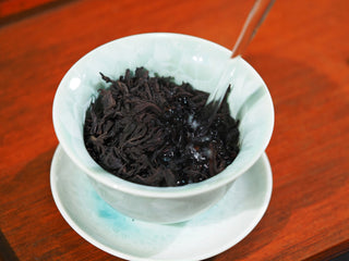 Pouring hot water into a gaiwan to brew Master-Roasted Da Hong Pao tea.