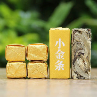 Comparison of wrapped and unwrapped Silver Needle white tea sticks showing the bold, big-leaf silver buds.