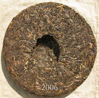 Back view of Mengku Rongshi Arbor King tea cake showing the compression hole and leaf quality.
