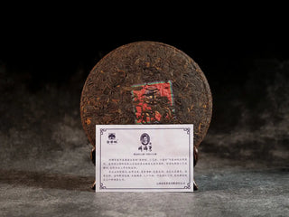 Unwrapped Qilin Hao Fengshan Gushu Ripe Pu-erh Tea Cake 2021 with product card, displaying clear leaf strips and red inner ticket