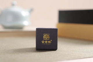 Close-up of a single serving Raw Pu-erh tea dragon pearl, highlighting the meticulous individual packaging.