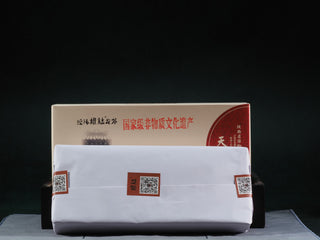 The 2015 Aged Fu Brick Tea wrapped in traditional paper, preserving the Golden Flora (Eurotium Cristatum) inside.
