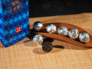 Xiaguan Wild Ancient Tree Dragon Pearl tea balls individually wrapped in silver foil.