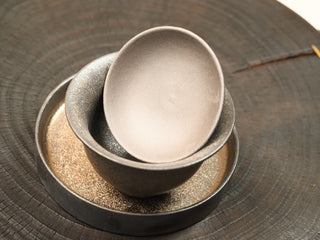 Wood-fired stoneware gaiwan bowl with tea tray from Dehua Fujian, showing the light interior glaze against the dark exterior.