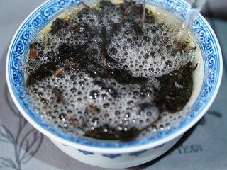 Brewing Floral Wuyi Rock Oolong – Jin Guanyin (204), with rich natural tea saponin foam forming in the gaiwan as hot water is poured.