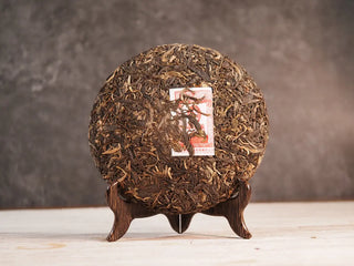 Front unwrapped view of 2019 Qilin Tribute Sheng Pu-erh Tea Cake – Ancient Arbor 357g, revealing tightly compressed ancient arbor tea leaves.