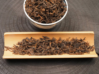 2024 Bulang Mountain bold ripe pu-erh loose leaves displayed on a bamboo tray