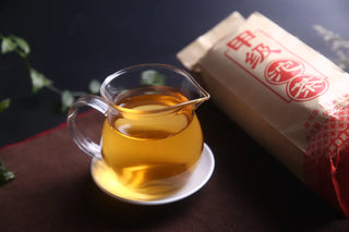 Golden bright tea liquor of brewed 2024 Premium Raw Puerh in a glass pitcher.