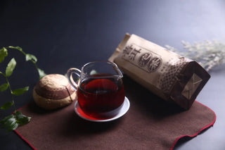 A professional tea setting featuring a glass Gongfu pitcher of sweet Lincang Ripe Pu-erh and the Tuo tea.