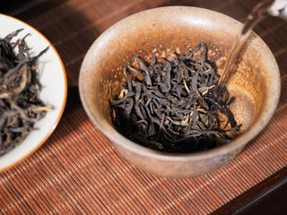 Steeping Ancient Tree Dianhong black tea in a rustic gaiwan