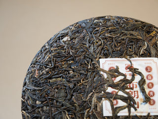 Close-up of internal ticket and compressed leaves on Bulang Mountain raw pu-erh tea cake