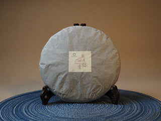 Unwrapped 2005 vintage Lincang Shou Pu-erh tea cake displaying clean aged appearance