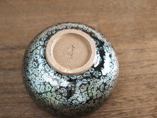 Unglazed base of a Da Chan Ding Jianzhan tea bowl with maker's mark, throwing rings, and trimmed foot ring typical of handcrafted Jianyang pottery.