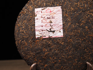 Close-up of the authentic inner trademark label (Neifei) embedded in the Dayi 7572 ripe puerh tea cake.

