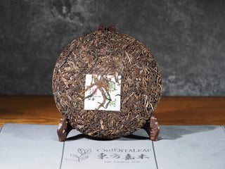 Front view of 2018 Dazhai Ancient Tree Raw Pu-erh Tea Cake without packaging, showcasing tea cake texture